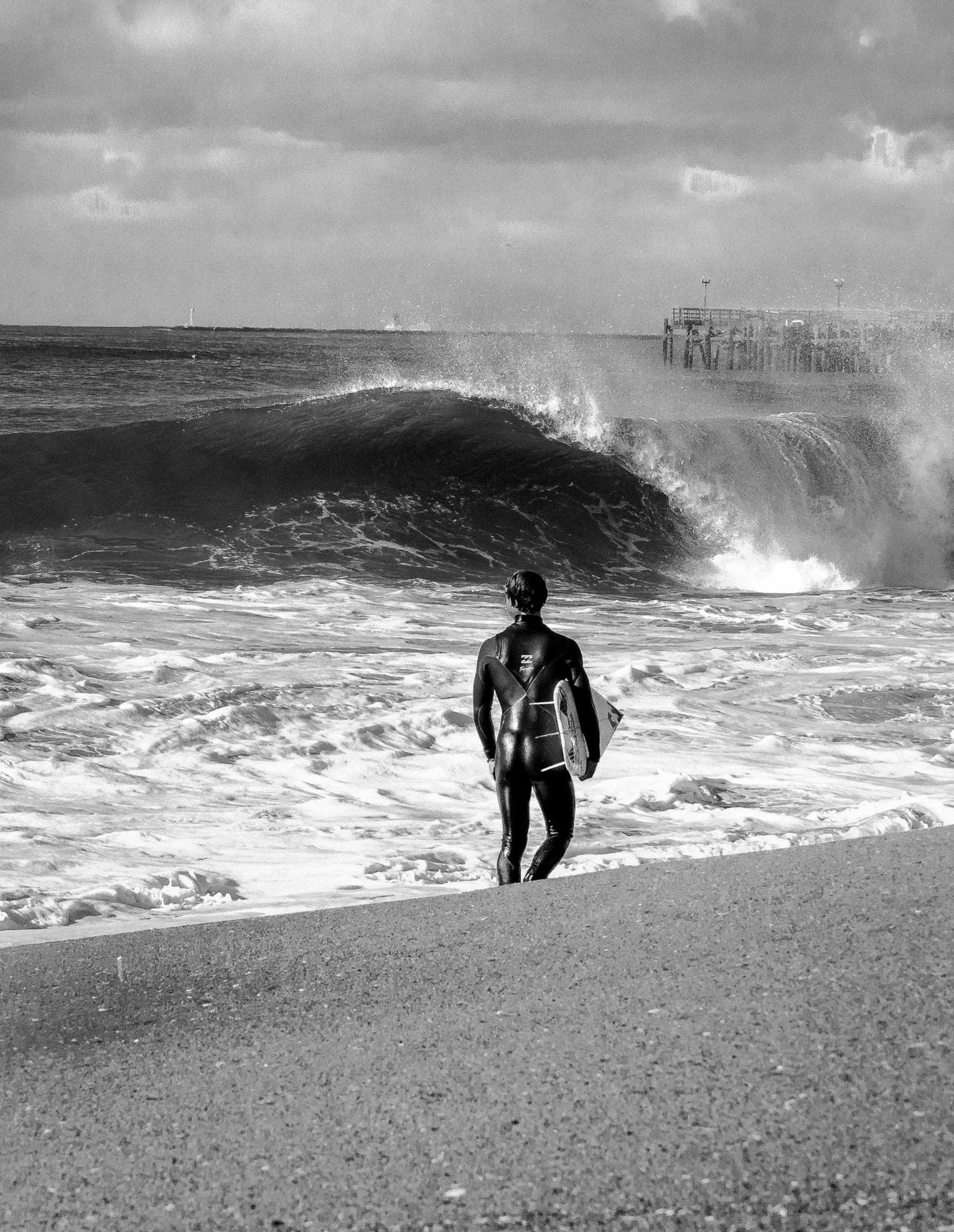 Surfer heading out at the pier